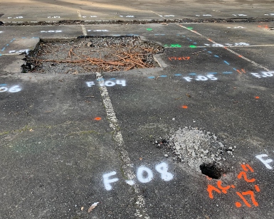 A "before" photo of the deteriorated parking lot pavement at McNears Beach Park.