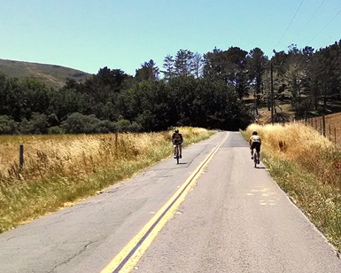 Two cyclists pass each other on a path near Walker Creek Ranch in rural West Marin.