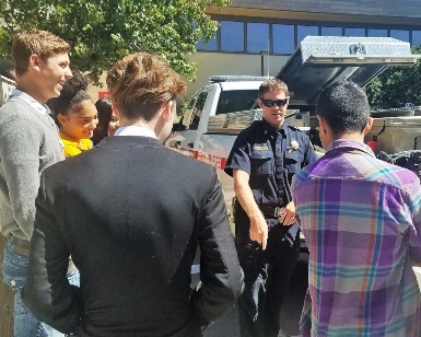 A fire department battalion chief talks to several young people during a Career Explorers meeting.