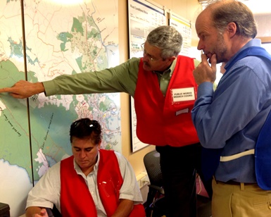 Several county workers evaluate a map on the wall during an emergency training exercise.