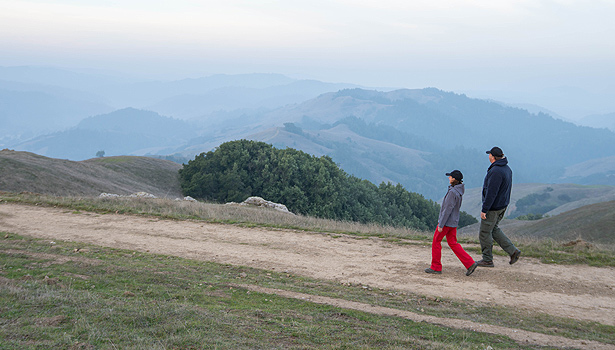 Woman and man walking on trail in morning mist