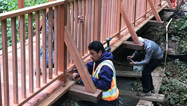 Construction workers fastening wooden railings