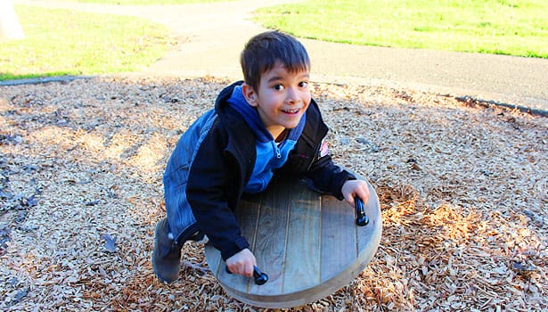 Young boy on the spinner at the playground