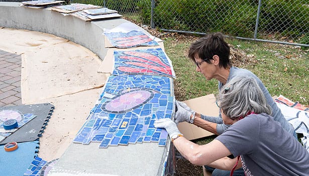 Artist and assistant constructing the mosaic