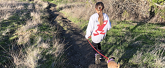 Girl walking dog on trail in Terra Linda